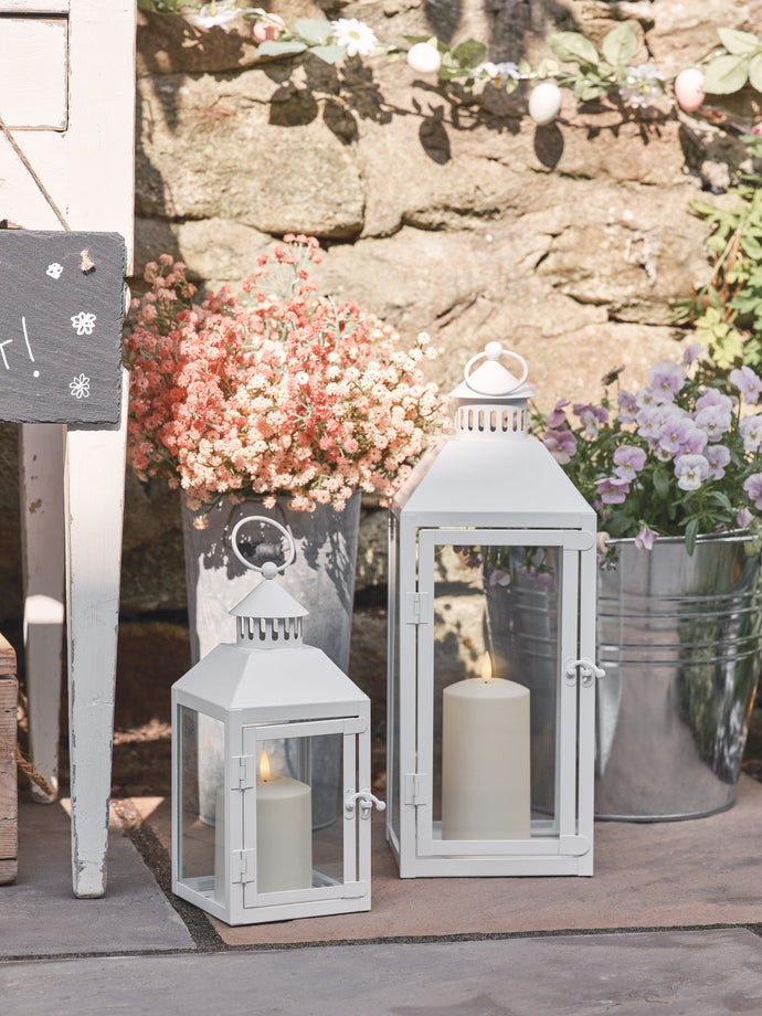 Trio of black metal lanterns with LED candles outdoors